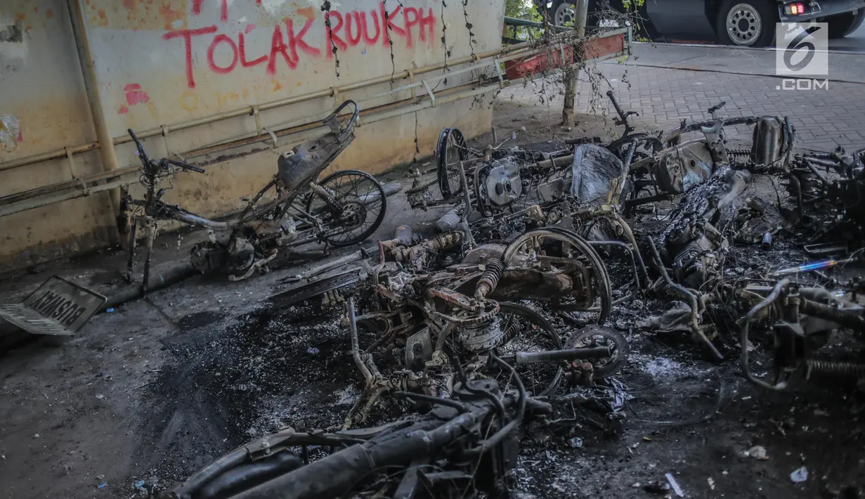 Bangkai sepeda motor usai dibakar massa aksi tergeletak di bawah jembatan layang Slipi, Jakarta, Kamis (26/9/2019). Aksi menolak revisi UU KPK, revisi UU KUHP dan sejumlah revisi UU lainnya berjalan anarkis di sekitar Gedung DPR pada Rabu 25 September 2019. (Liputan6.com/Faizal Fanani)