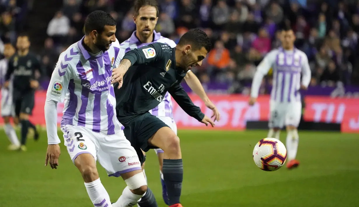 Gelandang Real Madrid, Daniel Ceballos berusaha menguasai bola dari kawalan bek Real Valladolid, Joaquin selama pertandingan lanjutan La Liga Spanyol di stadion Jose Zorrilla,Valladolid (10/3). Madrid menang 4-1 atas Valladolid. (AFP Photo/Cesar Manso)