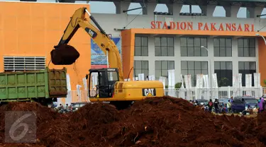 Alat berat melakukan proses pengerukan tanah di luar Stadion Pakansari, Kabupaten Bogor, Minggu (21/8). Jelang pelaksanaan PON XIX Jawa Barat, pembangunan sarana pertandingan di Stadion Pakansari terus dikerjakan. (Liputan6.com/Helmi Fithriansyah)