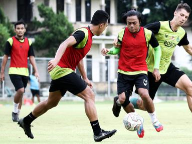 Pemain Persikabo 1973, Andre Oktaviansyah (tengah) berebut bola dengan Sergey Pushnyakov saat sesi latihan perdana di Lapangan Samudra, Badung, Bali, Minggu (03/01/2022). Latihan tersebut menjadi bagian dari persiapan menghadapi Arema FC  pada 5 januari mendatang. (Bola.com/Nandang Permana)