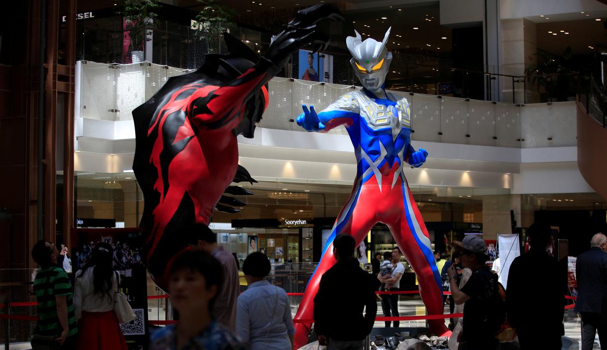 Pengunjung mengamati dua patung Ultraman setinggi lima meter yang dipamerkan di pusat perbelanjaan di Shanghai, China, Selasa (3/5/2016). Patung tersebut merupakan bagian dari pameran untuk memperingati ulang tahun Ultraman ke-50. (REUTERS/Aly Song)