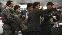 Pasukan keamanan Afghanistan membawa petugas yang terluka setelah ledakan bom bunuh diri di Kabul, Selasa (19/4). Belum ada pihak yang mengklaim soal siapa di balik serangan ini. Tetapi dugaan terkuat tertuju pada kelompok Taliban. (REUTERS/Omar Sobhani)