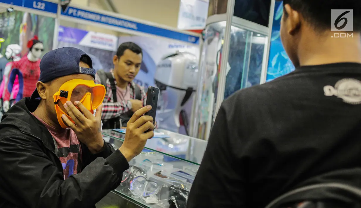 Pengunjung menjajal kacamata diving dalam pameran Deep and Extreme Indonesia (DXI) 2019 di Jakarta, Kamis (4/4). DXI 2019 menghadirkan 174 booth dan lebih dari 220 perusahaan terkait wisata bahari dan ekstrem. (Liputan6.com/Faizal Fanani)