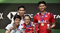 Praveen Jordan/Melati Daeva Oktavianti memamerkan medali emas All England 2020 usai menaklukkan Dechapol Puavaranukroh/Sapsiree Taerattanachai di final, Minggu (15/3/2020). (AP Photo/Rui Vieira)