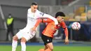 Bek Real Madrid, Raphael Varane , berebut bola dengan gelandang Shakhtar Donetsk, Taison, laga lanjutan Liga Champions di NSK Olimpiyskiy, Rabu (2/12/2020) dini hari WIB. Real Madrid kalah 0-2 oleh Shakhtar Donetsk. (AFP/Sergei Supinsky)