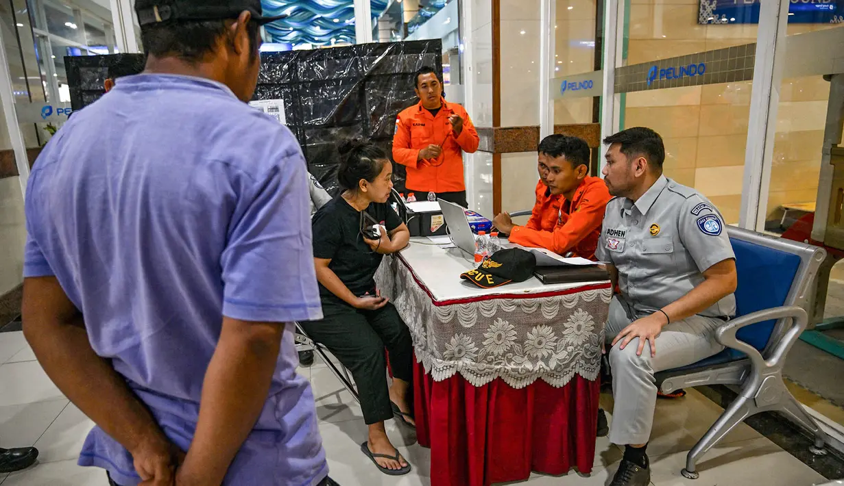 Petugas Basarnas melayani warga yang bertanya tentang informasi penumpang kapal KM Mutiara Sentosa 2 di posko informasi, Gapura Surya Nusantara, Pelabuhan Tanjung Perak, Surabaya, Jawa Timur, Minggu (2/8/2026). (AFP/ Juni Kriswanto)