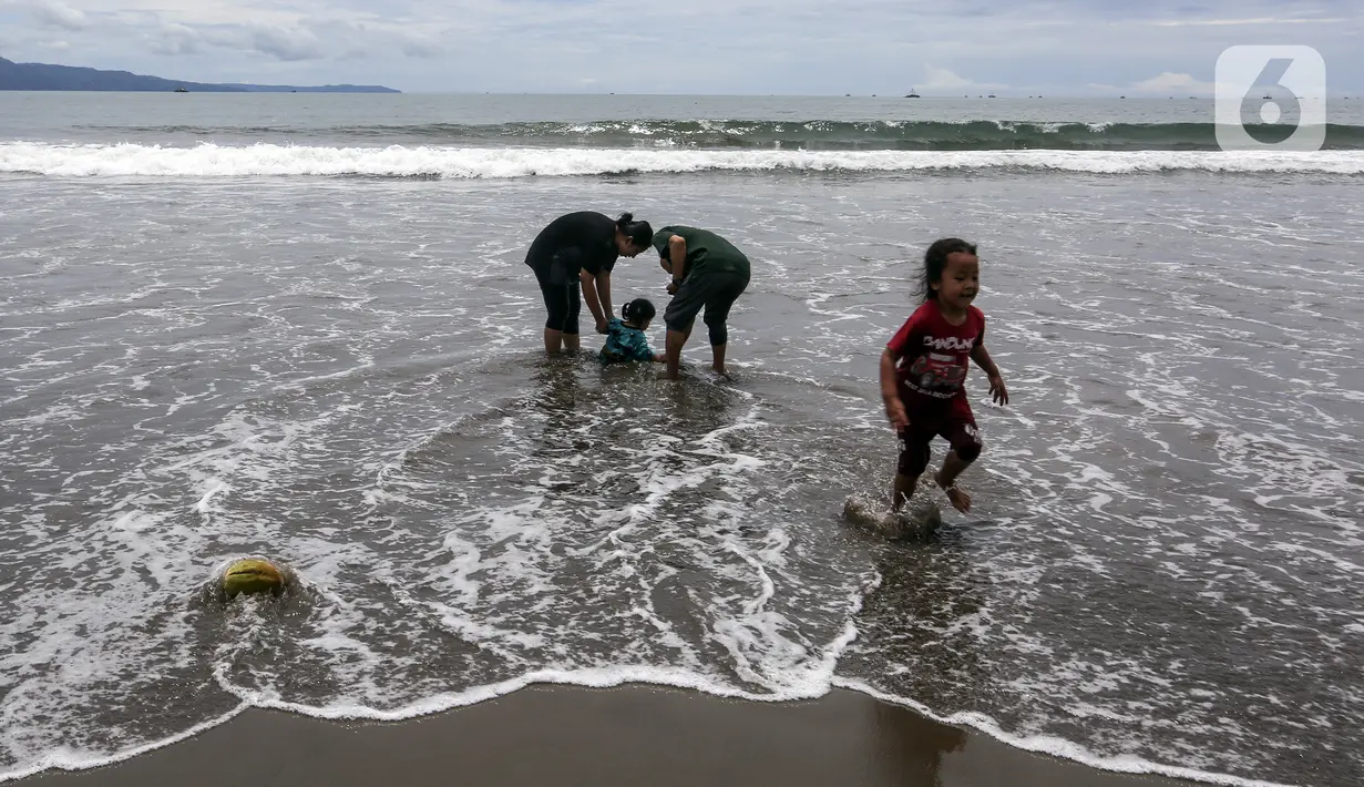 Warga bermain air di Pantai Pelabuhan Ratu, Kabupaten Sukabumi, Jawa Barat, Jumat (12/11/2021). Penerapan Pemberlakuan Pembatasan Kegiatan Masyarakat (PPKM) Level 1 membolehkan objek wisata kembali buka, salah satunya Pantai Pelabuhan Ratu. (Liputan6.com/Johan Tallo)
