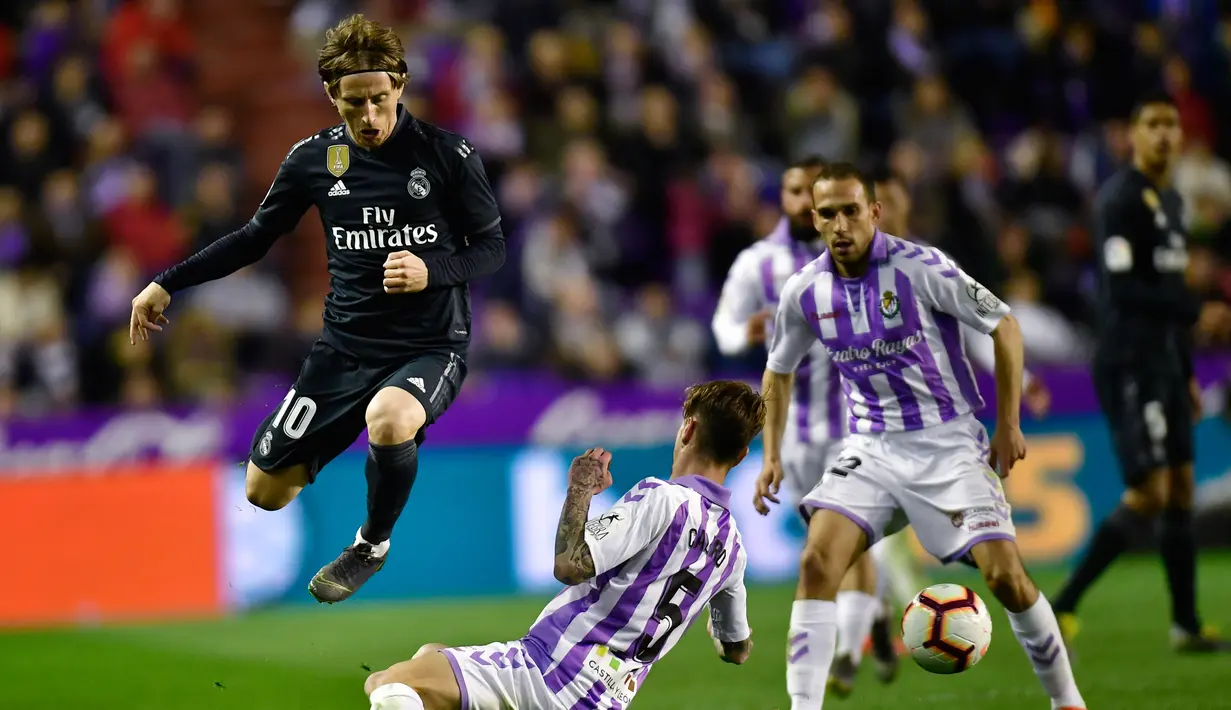 Gelandang Real Madrid, Luka Modric berusaha melewati pemain Real Valladolid, Luismi Sanchez selama pertandingan lanjutan La Liga Spanyol di stadion Jose Zorrilla,Valladolid (10/3). Madrid menang telak 4-1 atas Valladolid. (AP Photo/Alvaro Barrientos)