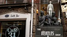 Seorang wanita tampak dari jendela sebuah toko bernama Beatles Shop di Liverpool, Inggris, (2/3). Warga Liverpool Peringati 50 tahun terakhir kali The Beatles melakukan konser di kota asal mereka ini. (REUTERS/Phil Noble)
