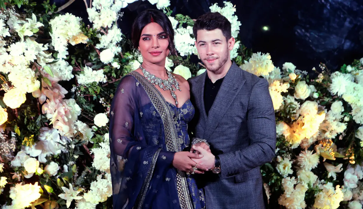 Pasangan aktris Bollywood Priyanka Chopra dan musisi Nick Jonas berpose untuk resepsi pernikahan mereka di Mumbai, India, Rabu (19/12). Resepsi kedua Priyanka Chopra dan Nick Jonas hanya mengundang kerabat dan teman dekat. (AP/Rajanish Kakade)