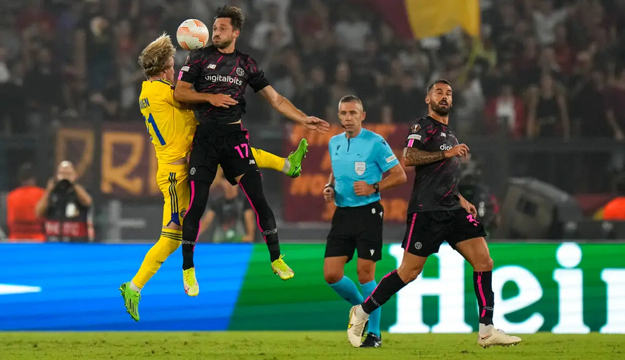 Pemain HJK Helsinki Santeri Vaanaenen (kiri) berebut bola udara dengan pemain AS Roma Matias Vina pada pertandingan sepak bola Liga Europa di Stadion Olimpiade Roma, Italia, 15 September 2022. AS Roma menang dengan skor 3-0. (AP Photo/Alessandra Tarantino)