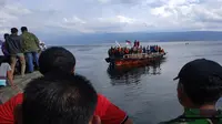 Warga menyaksikan kapal yang digunakan Tim SAR Gabungan untuk mengevakuasi KM Sinar Bangun yang tenggelam di Danau Toba. (Prayugo Utomo/JawaPos.com)