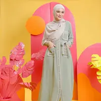 Hadir dengan nuansa pastel adalah pilihan yang tepat, lho. Kamu dapat mengenakan gamis berwarna sage green dengan detail list nude pada saku, belt dan kancing. (instagram/shireensungkar)
