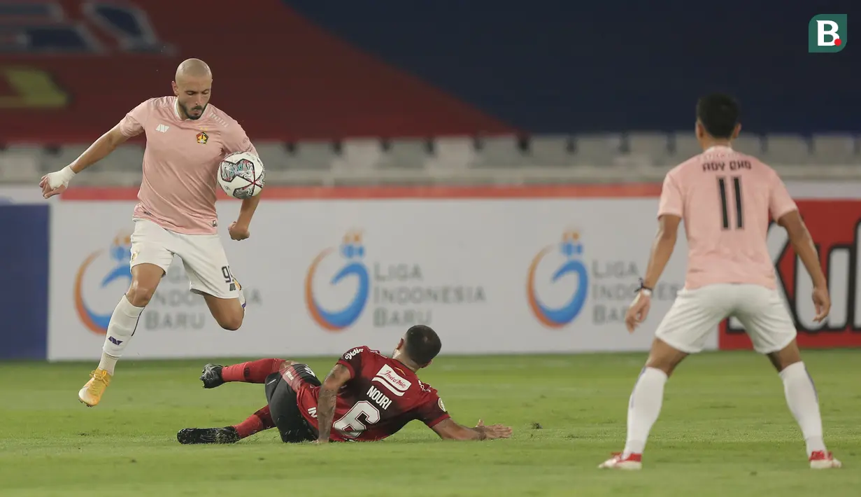 Pemain Persik Kediri, Youssef Ezzejjari (kiri) berusaha melewati hadangan pemain Bali United Brwa Hekmat Nouri dalam laga pembukaan BRI Liga 1 2021/2022 antara Bali United melawan Persik Kediri di Stadion Utama Gelora Bung Karno, Jumat (27/8/2021). (Foto: