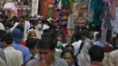 Orang-orang mengabaikan jarak sosial dan banyak yang tidak memakai masker wajah saat berbelanja untuk liburan Idul Fitri mendatang yang menandai akhir bulan suci puasa Ramadhan setelah pemerintah mengumumkan pembatasan baru, di Rawalpindi, Pakistan, Rabu (5/5/2021). (AP Photo/Anjum Naveed)