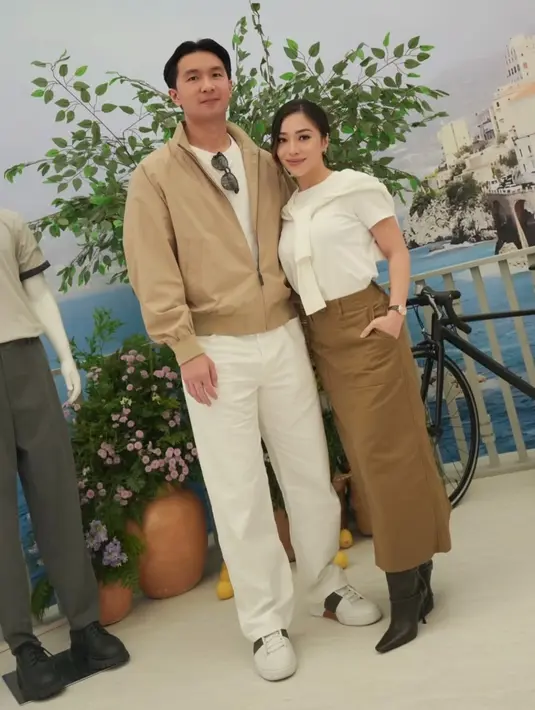 Atasan serba putih tersebut dipadukan dengan rok span coklat panjang serta sepatu boots heels hitamnya.  [@nikitawillyofficial94]