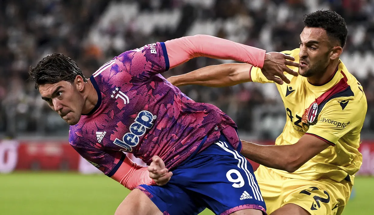 Pemain depan Juventus Dusan Vlahovic berebut bola dengan bek Bologna Charalampos Lykogiannis pada pekan kedelapan Liga Italia 2022-2023 di Allianz Stadium, Senin (3/10/2022) dini hari WIB. Juventus mengakhiri paceklik kemenangan usai menaklukkan tim tamu Bologna. (Marco Alpozzi/LaPresse via AP)