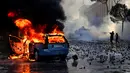 Sebuah mobil terbakar saat bentrokan pecah dalam aksi demonstrasi antipemerintah di luar kantor Perdana Menteri di Tirana, Albania, Sabtu (17/10/2026). (AP Photo/Hameraldi Agolli)
