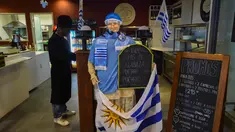 Bendera Uruguay dipajang di sebuah bar di Montevideo (4/7). Warga Uruguay antusias mempersiapkan untuk mendukung negaranya bertanding melawan Prancis pada babak 8 besar Piala Dunia 2018 di Rusia. (AFP Photo/Miguel Rojo)