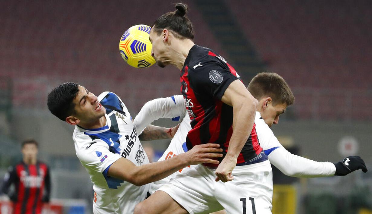 Striker AC Milan, Zlatan Ibrahimovic, duel udara dengan pemain Atalanta pada laga Liga Italia di Stadion San Siro, Sabtu (23/1/2021). AC Milan takluk dengan skor 0-3. (AP/Antonio Calanni)