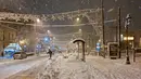 Seorang penduduk setempat mencoba untuk mengejar taksi di jalan yang tertutup salju di Athena, Senin (24/1/2022). Otoritas Yunani mengumumkan hari libur umum pada 25 Januari, untuk menghindari mobilitas karena cuaca dingin dengan hujan salju lebat dan suhu yang sangat rendah. (Louisa GOULIAMAKI/AFP)