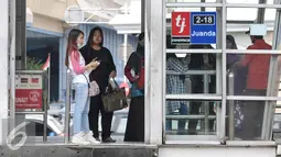 Sejumlah penumpang menunggu kedatangan bus Transjakarta di Halte Juanda, Jakarta, Sabtu (19/11). Transjakarta lakukan penambahan jam layanan operasional untuk penuhi kebutuhan transportasi masyarakat di malam hari. (Liptan6.com/Yoppy Renato)