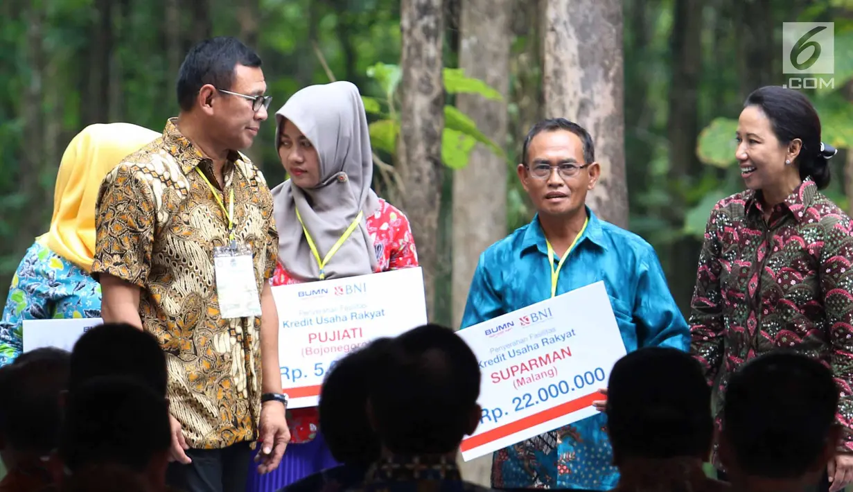 Menteri BUMN Rini Soemarno (kanan) menyalurkan KUR kepada petani penggarap lahan hutan melalui Program Perhutanan Sosial di Tuban, Jawa Timur, Jumat (9/3). Pemerintah menyalurkan KUR, Kartu Tani, dan CSR BNI. (Liputan6.com/Angga Yuniar)