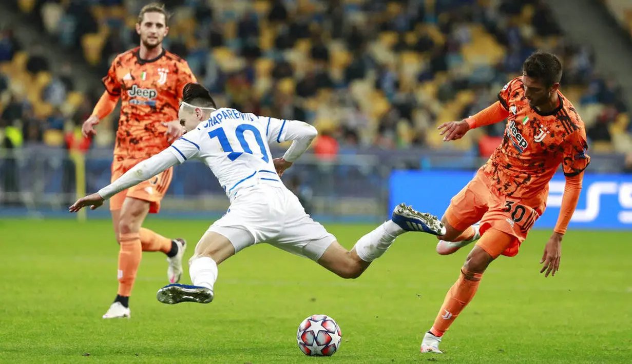 Pemain Juventus, Rodrigo Bentancur, berebut bola dengan pemain Dynamo Kyiv, Mykola Shaparenko, pada laga Liga Champions di Stadion Olimpiyskiy, Rabu (21/10/2020). Juventus menang dengan skor 2-0. (Valentyn Ogirenko/Pool via AP)