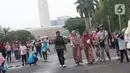 Warga berjalan-jalan di kawasan Monumen Nasional, Jakarta, Rabu (25/12/2019). Libur perayaan Natal 2019 dimanfaatkan warga Jakarta dan sekitarnya berwisata di Monumen Nasional. (Liputan6.com/Helmi Fithriansyah)