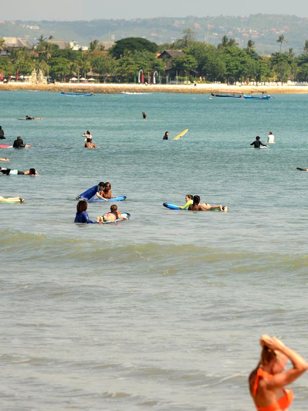 Turis berselancar di pantai Kuta dekat Denpasar di pulau resor Indonesia di Bali (3/5). Daerah ini merupakan sebuah tujuan wisata turis mancanegara dan telah menjadi objek wisata andalan Pulau Bali sejak awal tahun 1970-an. (AFP Photo/Sonny Tumbelaka)