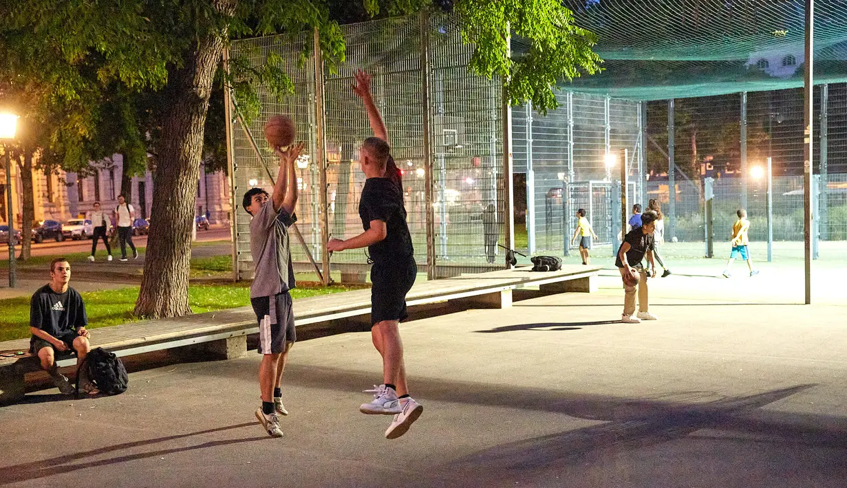 Sejumlah orang bermain bola basket di sebuah taman olahraga jalanan di Wina, Austria, Rabu (8/7/2020). Sejumlah orang di Wina pergi ke taman olahraga jalanan untuk melakukan olahraga luar ruangan setelah pembatasan COVID-19 dicabut. (Xinhua/Georges Schneider)