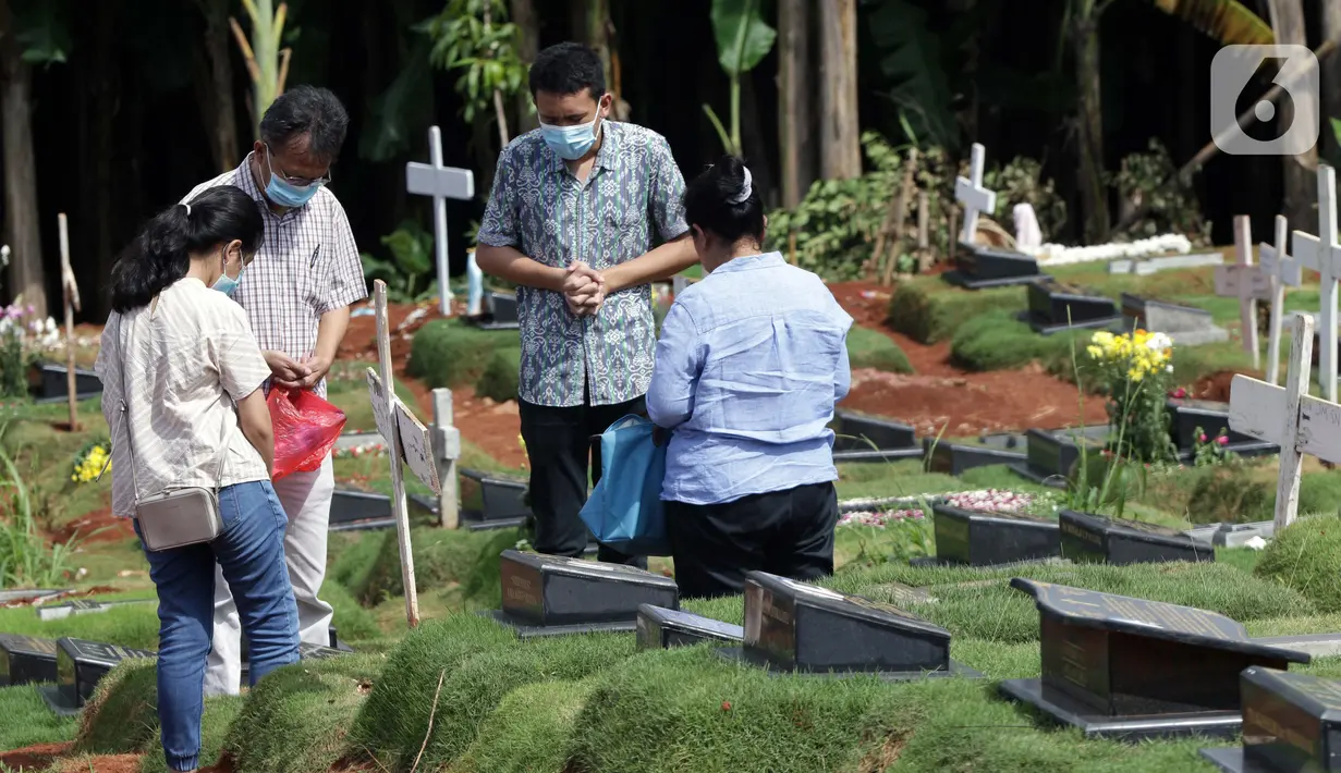 Warga berziarah di area pemakaman khusus dengan protokol COVID-19 di TPU Pondok Ranggon, Jakarta, Jumat (25/12/2020). Momen perayaan Natal 2020 dimanfaatkan sejumlah umat kristiani untuk berziarah mendoakan kerabat yang dimakamkan dengan protokol COVID-19. (Liputan6.com/Helmi Fithriansyah)