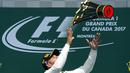 Lewis Hamilton melempar trofi juara setelah menang  pada ajang Formula One Canadian Grand Prix di Montreal, Canada, (11/6/2017).  (Paul Chiasson/The Canadian Press via AP)