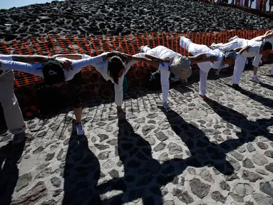 Sekelompok orang melakukan gerakan yoga diatas Piramida Matahari saat merayakan equinox musim semi di situs arkeologi Teotihuacan, Meksiko (21/3). Ritual itu diikuti oleh ribuan pengunjung yang naik ke piramida kuno. (AP Photo/Rebecca Blackwell)