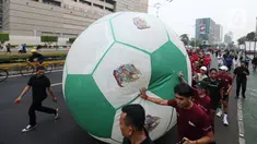 Masyarakat mengglindingkan bola raksasa dari Sarina ke Bundaran HI saat Trophy Experience Piala Dunia U-17 2023 di car free day (CFD) kawasan Jalan Thamrin, Jakarta, Minggu (15/10/2023). Kegiatan tersebut dalam rangka promosi ajang Piala Dunia U-17 2023 di Indonesia. (Liputan6.com/Faizal Fanani)