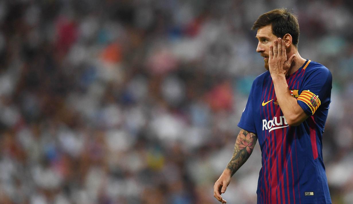 Striker Barcelona, Lionel Messi, mengusap pipinya usai takluk dari Real Madrid pada laga Piala Super Spanyol 2017 di Stadion Santiago Bernabeu, Rabu (16/8/2017). Real Madrid menang 2-0 atas Barcelona. (AFP/Gabriel Bouys)