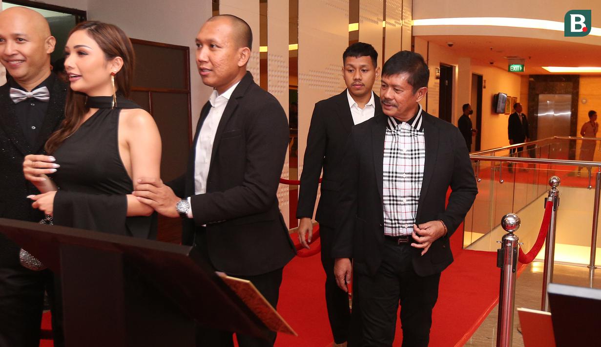 Pelatih kepala Timnas Indonesia U-22, Indra Sjafri berjalan di atas karpet merah pada sebuah acara yang berlangsung di Hotel JS Luwansa, Kuningan, Jakarta, Rabu (19/07/2023). Coach Indra terlihat mengenakan jas hitam dipadukan dengan kemeja bermotif kotak-kotak. (Bola.com/Bagaskara Lazuardi)