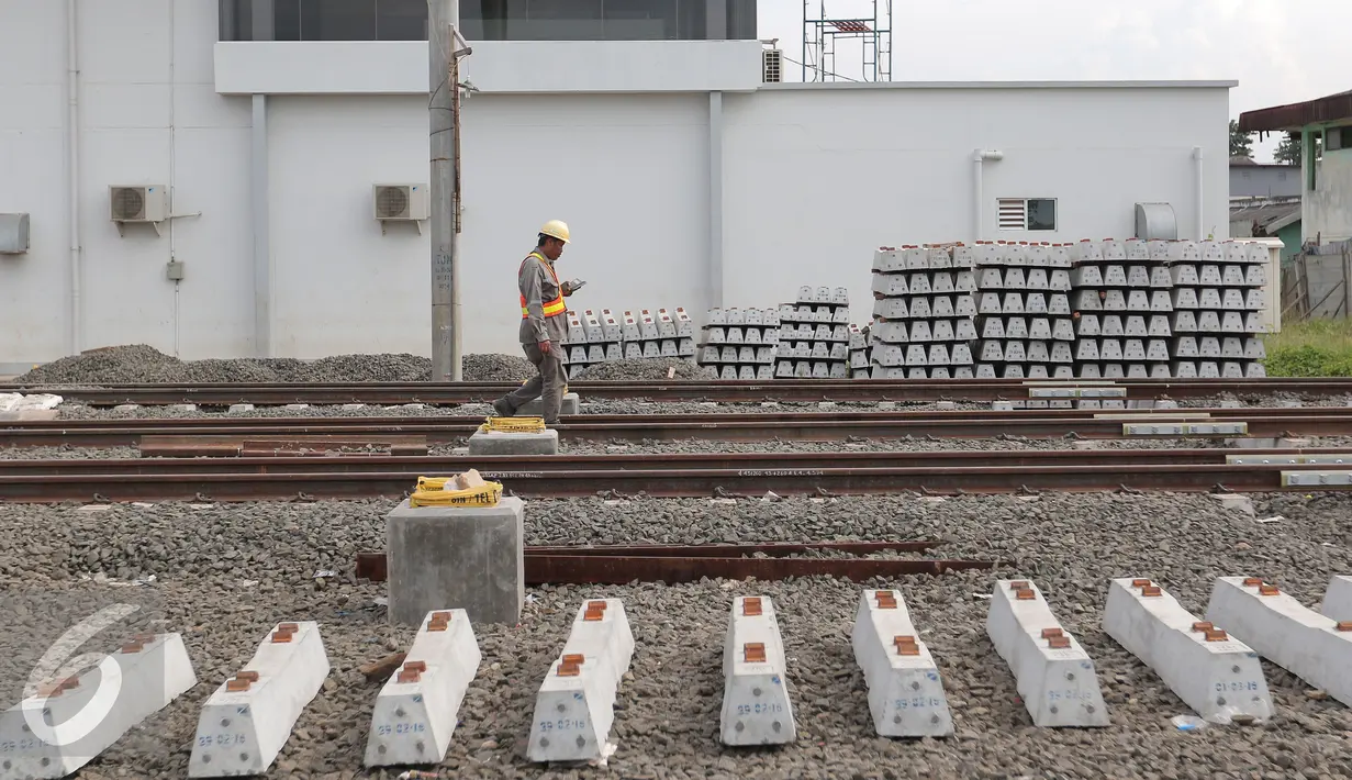 Pekerja melintasi rel di area proyek  pembangunan Stasiun Commuter Line Cikarang, Jawa Barat, Selasa (12/4). Proyek ini ditargetkan selesai dan bisa dioperasikan pada 2018. (Liputan6.com/Angga Yuniar)