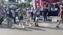 Pembalap sepeda wanita UCI MTB Eliminator 2024 asal Brasil, Aline Simoes (tengah) saat mengikuti rangkaian acara Festival Budaya Isen Mulang di Bundaran Palangkaraya, Minggu (19/5/24) pagi. (Bola.com/Ade Yusuf Satria)