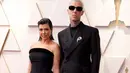 Kourtney Kardashian hadir di Oscar 2022 bersama sang tunangan, Travis Barker. Pasangan ini terlihat serasi kenakan busana all black.  Kourtney kenakan dress dari Tab Vintage, sementara Travis kenakan tuksedo dari Maison Margiela. (Instagram/ fashionbombdaily).