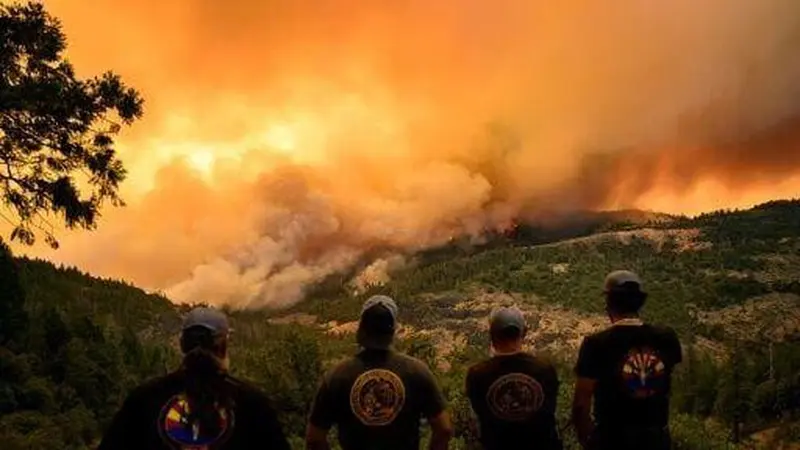 Petugas pemadam kebakaran menyaksikan api dan asap bergerak melalui lembah di area Forest Ranch di Butte County saat kebakaran terus membakar di dekat Chico, California. (AFP/Josh Edelson)