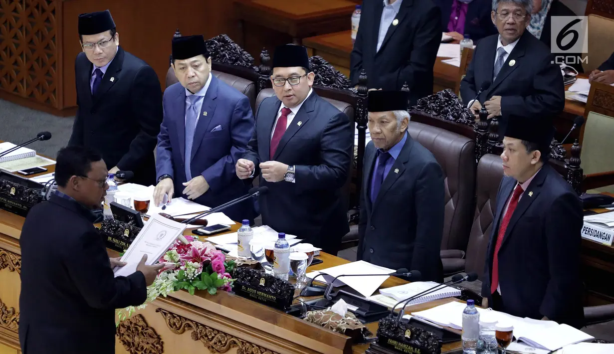 Wakil Ketua DPR Fadli Zon  disaksikan Setya Novanto bersiap menerima berkas dalam rapat paripurna di kompleks parlemen, Jakarta, Kamis (20/7). Ini kali pertama Setnov menghadiri paripurna sejak ditetapkan sebagai tersangka e-KTP (Liputan6.com/Johan Tallo)