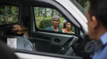 Seorang warga berkerumun melihat penemuan mayat dalam mobil di kawasan Taman Wiladatika, Jakarta Timur, Minggu (3/5/2015). Mayat pria yang diketahui bernama Sunoto (41) tersebut ditemukan oleh seorang penyapu jalanan. (Liputan6.com/Faizal Fanani)