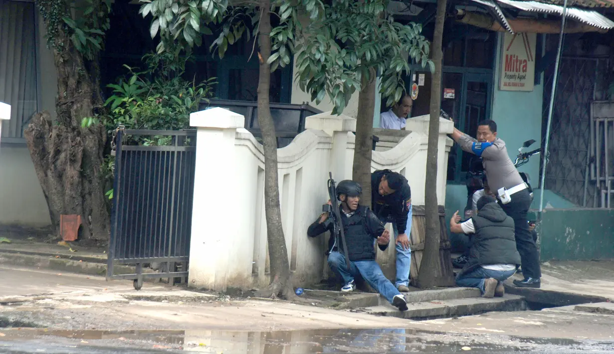 Polisi bersenjata api lengkap mengepung kantor Kelurahan Arjuna, Kecamatan Cicendo, Bandung, Senin (27/2). Baku tembak antara polisi dan seorang terduga teroris yang meledakkan benda di Taman Pandawa, terjadi di kantor lurah tersebut. (Timor Matahari/AFP)