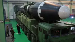 Pemimpin Korea Utara Kim Jong Un (ketiga kiri) memeriksa Rudal Hwasong-15 versi terbaru dari Hwasong-14, yang pernah diuji coba Juli lalu. (KCNA/Korea News Service via AP)