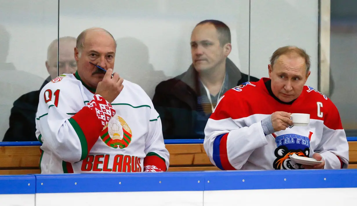 Presiden Rusia Vladimir Putin (kanan) dan Presiden Belarusia Alexander Lukashenko beristirahat saat mengikuti Night Hockey League di Sochi, Rusia, Jumat (7/2/2020). Putin dan Lukashenko bermain hoki bersama saat jeda pembicaraan ekonomi antara kedua negara. (AP Photo/Alexander Zemlianichenko, Pool)