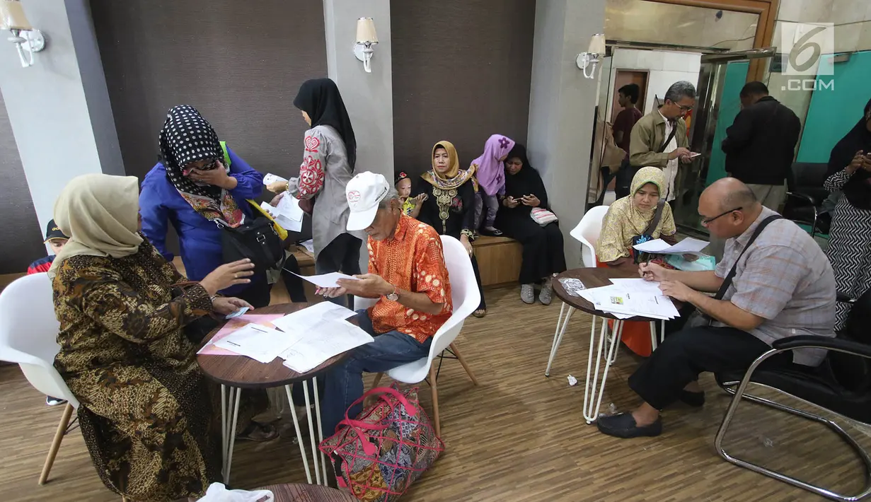 Korban dugaan penipuan perjalanan umrah First Travel mengisi formulir di Posko Pengaduan Korban PT First Travel Bareskrim Polri, Jakarta, Senin (21/8). Total lebih dari 1.200 calon jemaah umrah mendaftar ke Bareskrim. (Liputan6.com/Immanuel Antonius)