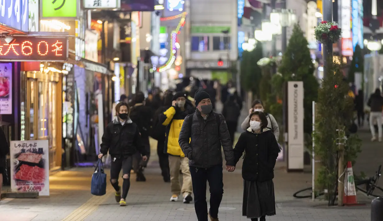 Orang-orang berjalan di sekitar lingkungan Shinjuku Tokyo, Kamis (7/1/2021). Keadaan darurat untuk Tokyo tersebut untuk memerangi peningkatan infeksi Virus Corona COVID-19. (AP Photo/Hiro Komae)