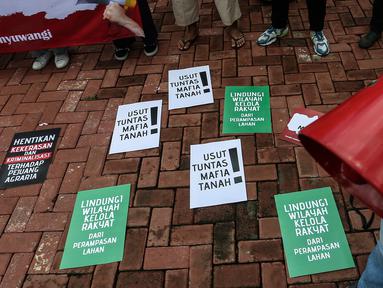 Sejumlah poster diletakan saat melakukan aksi di depan Mabes Polri, Jakarta, Jumat (21/1/2022). Mereka menuntut kekerasan yang dilakukan oknum aparat kepolisian terhadap Warga Rukun Tani Sumberejo Pakel, Desa Pakel, Banyuwangi, Jawa Timur. (Liputan6.com/Johan Tallo)