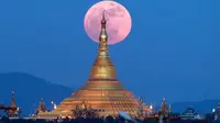 Penampakan fenomena supermoon dari balik pagoda Uppatasanti di langit Naypyitaw, Myanmar, Minggu (3/12). Supermoon adalah istilah populer untuk menyebut purnama yang posisi orbit Bulan sedang berada di jarak terdekat dengan Bumi. (AP/Aung Shine Oo)